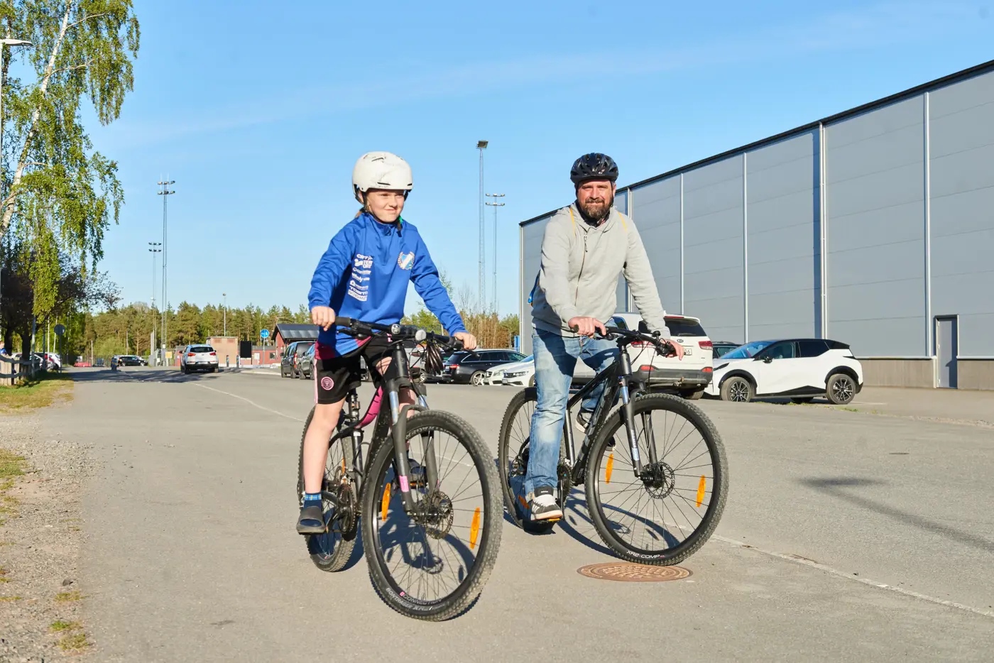 En pappa och ett barn cyklar.